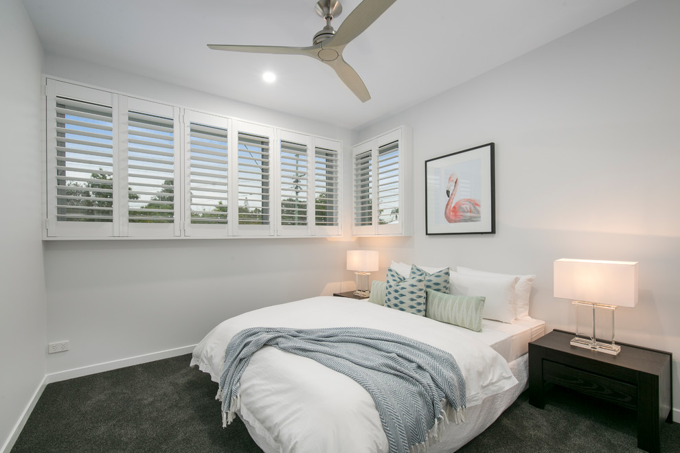 This is an example of a large contemporary guest bedroom in Brisbane with white walls, carpet and black floors.