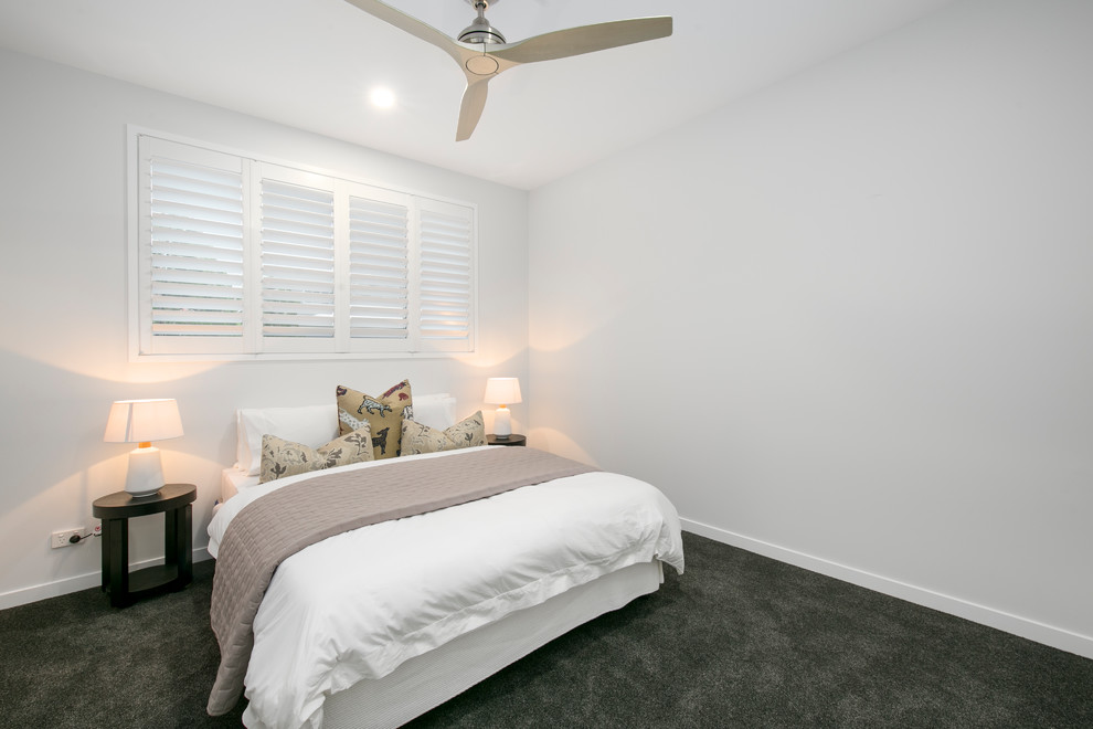 ブリスベンにある広いコンテンポラリースタイルのおしゃれな客用寝室 (白い壁、カーペット敷き、暖炉なし、黒い床) のインテリア