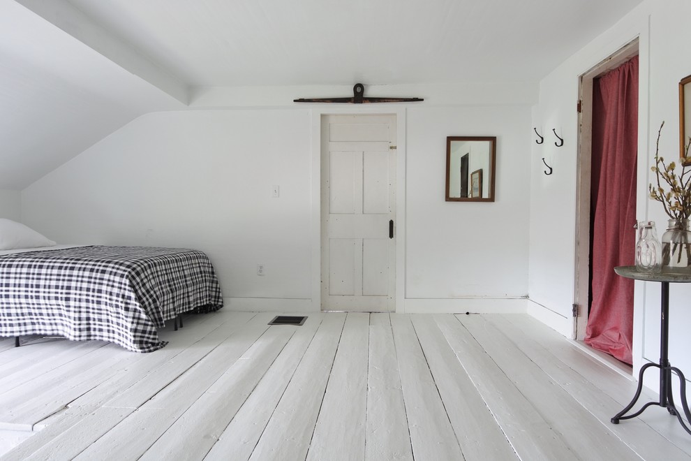 Cette image montre une petite chambre d'amis rustique avec un mur blanc, un sol blanc, un sol en contreplaqué et aucune cheminée.