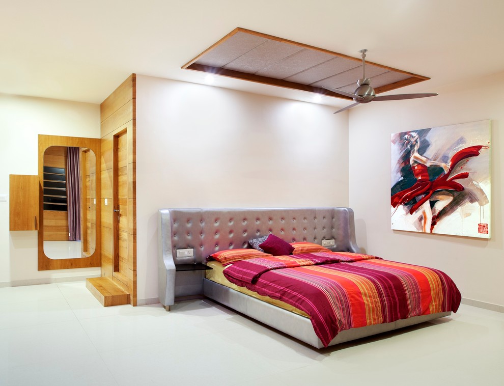 Modern guest bedroom in Bengaluru with white walls and marble flooring.