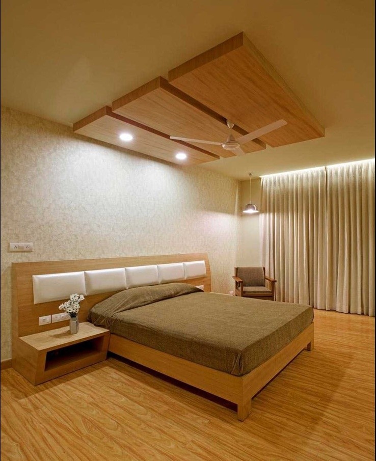 Foto de habitación de invitados actual con paredes beige y suelo de contrachapado