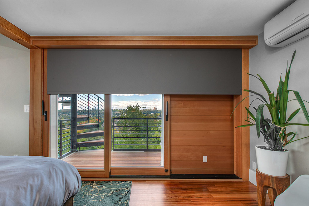 Contemporary master bedroom in Seattle with beige walls, medium hardwood flooring, no fireplace and brown floors.