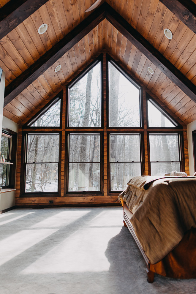 На фото: большая спальня в стиле рустика с ковровым покрытием, зеленым полом и деревянным потолком