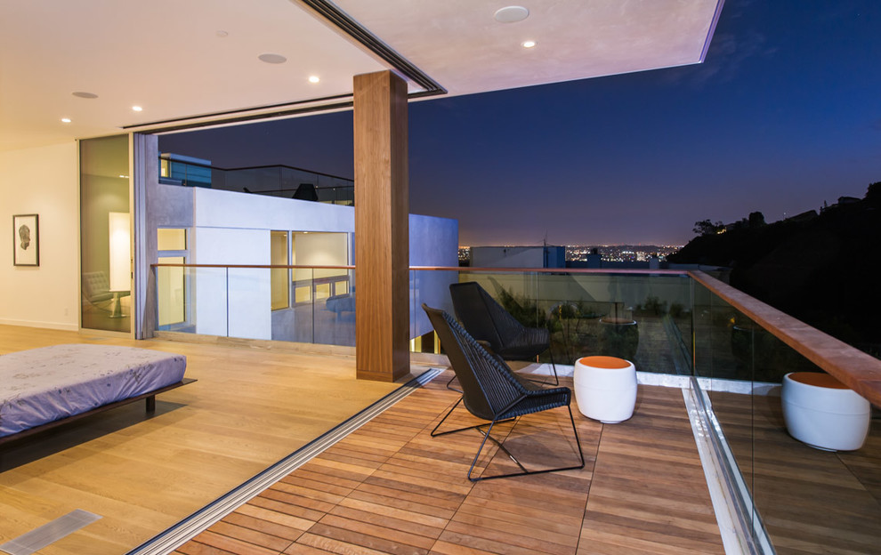 Expansive modern master bedroom in Los Angeles with white walls and light hardwood flooring.