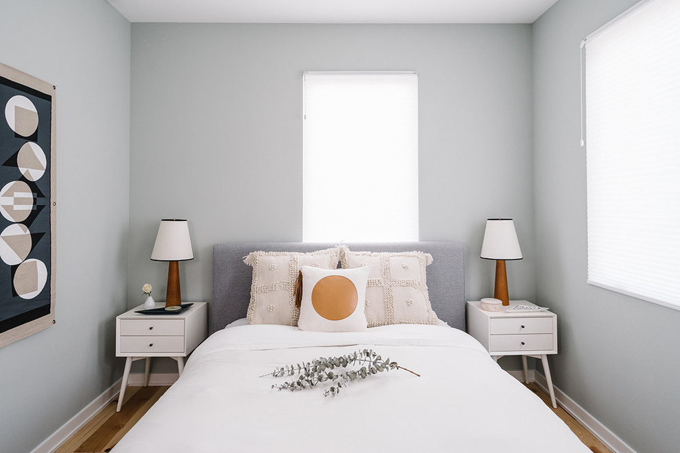 Modelo de habitación de invitados escandinava pequeña sin chimenea con paredes grises y suelo de madera clara