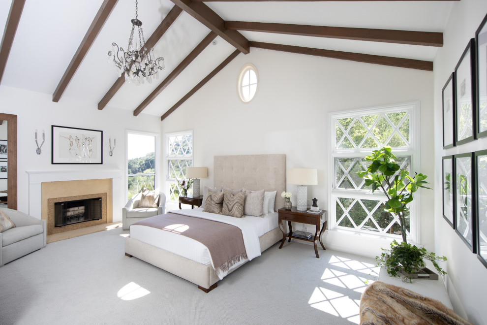 Идея дизайна: хозяйская спальня в морском стиле с белыми стенами, ковровым покрытием, стандартным камином, серым полом и балками на потолке