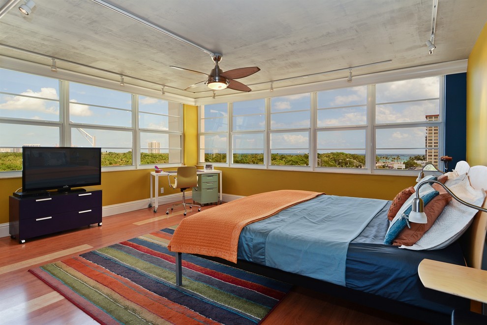 Example of an urban medium tone wood floor bedroom design in Miami with multicolored walls