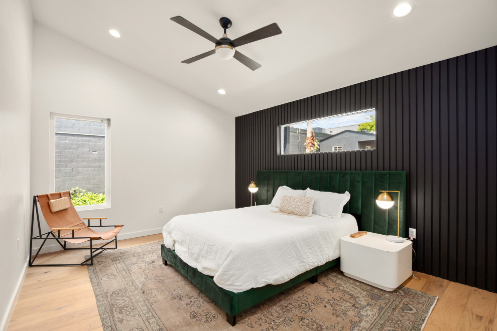 オースティンにあるコンテンポラリースタイルのおしゃれな寝室 (黒い壁、無垢フローリング、茶色い床、三角天井)