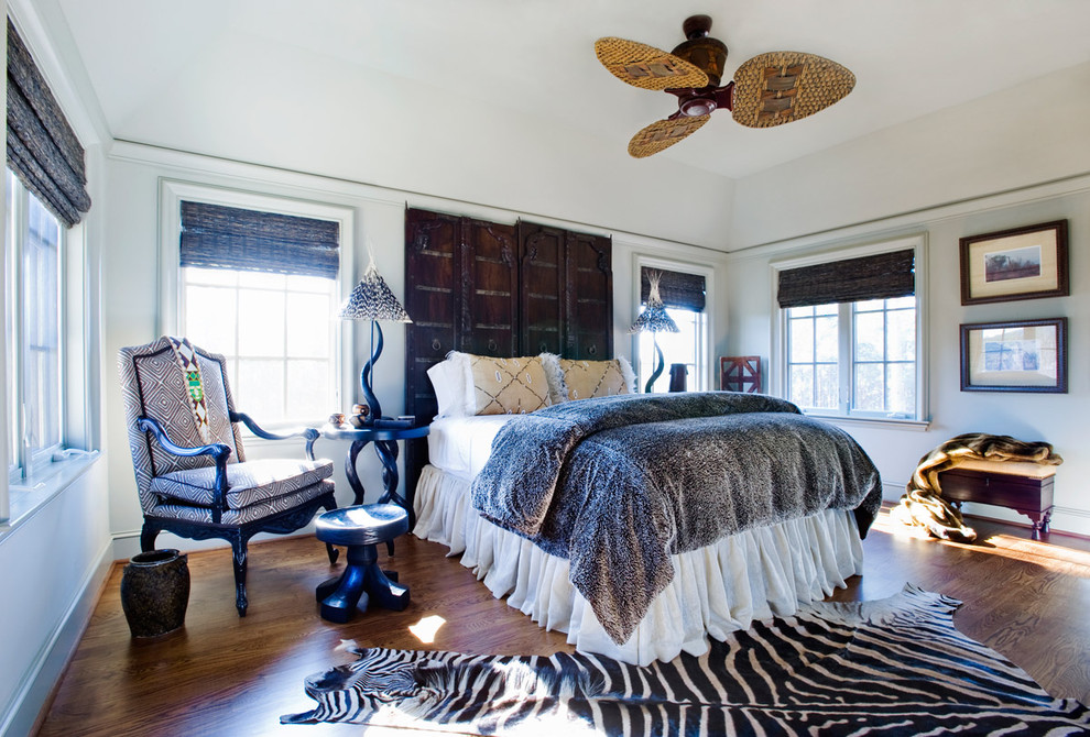 Photo of a large eclectic guest bedroom in Other with white walls, dark hardwood flooring, no fireplace and brown floors.
