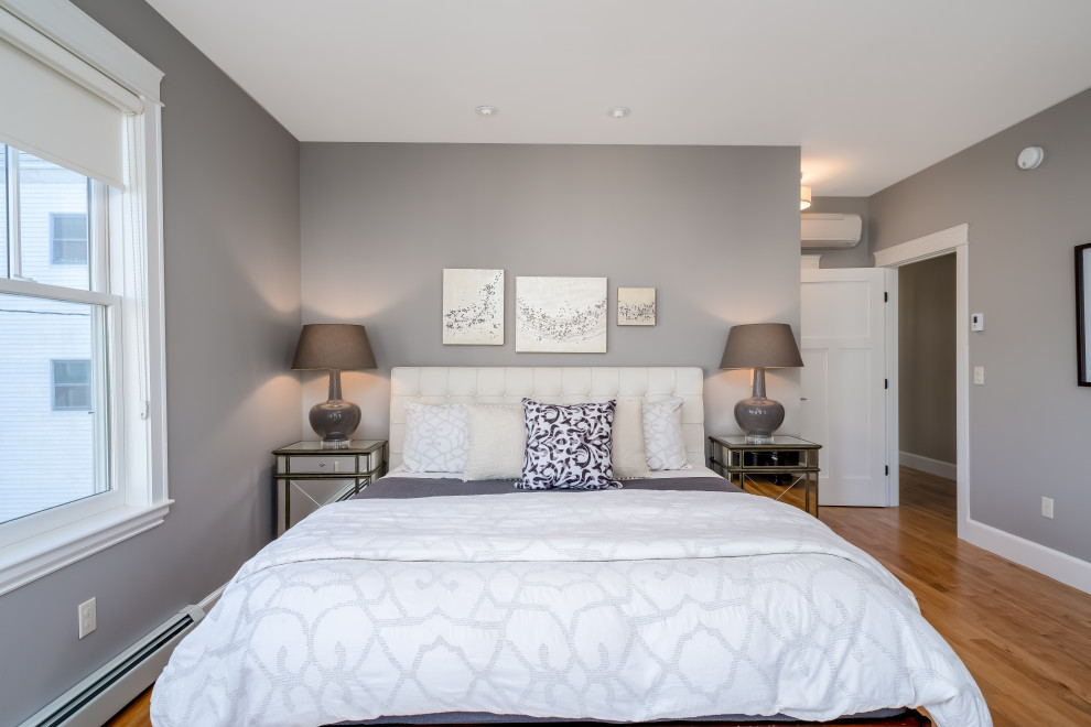 Diseño de dormitorio principal tradicional renovado de tamaño medio con paredes grises, suelo de madera en tonos medios y suelo marrón