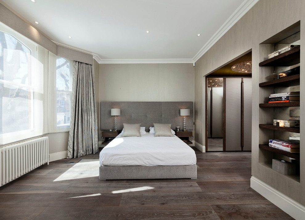 Großes Hauptschlafzimmer ohne Kamin mit grauer Wandfarbe und braunem Holzboden in London