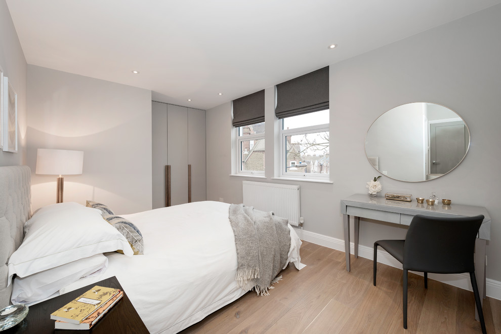 Kleines Klassisches Hauptschlafzimmer mit grauer Wandfarbe, hellem Holzboden und beigem Boden in London