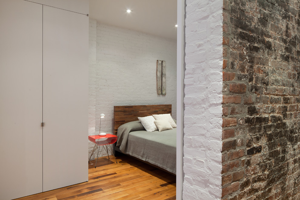 Ejemplo de dormitorio contemporáneo con paredes blancas y suelo de madera en tonos medios