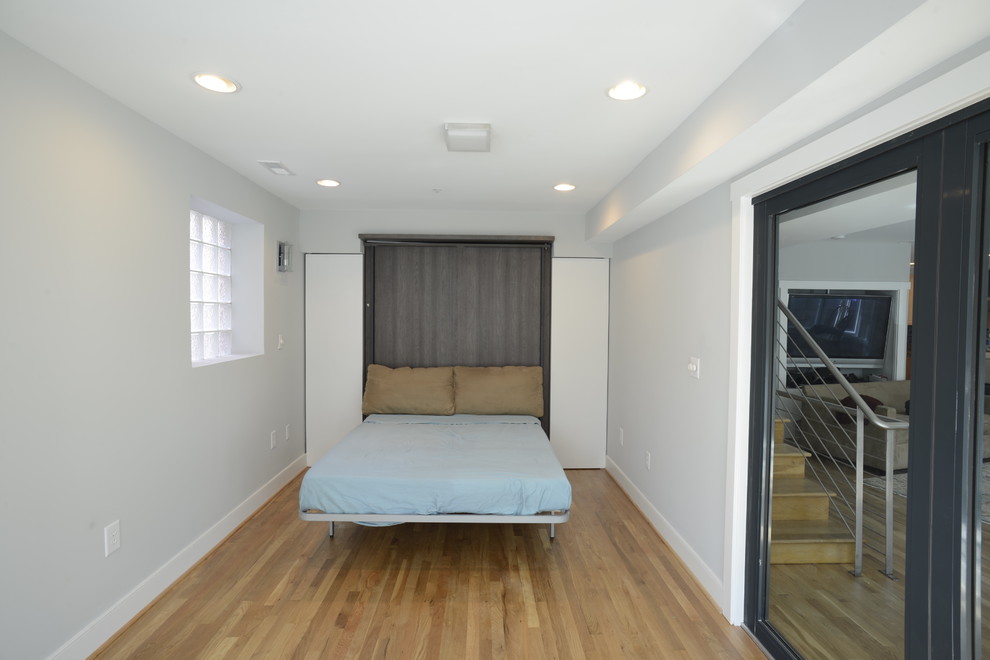 Design ideas for a small modern guest bedroom in DC Metro with white walls, light hardwood flooring and no fireplace.
