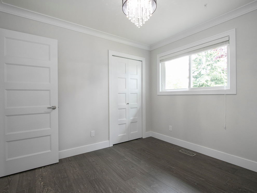 Ejemplo de habitación de invitados actual de tamaño medio con paredes grises y suelo de madera oscura