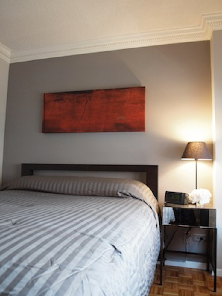 Esempio di una piccola camera da letto chic con pareti grigie e parquet chiaro