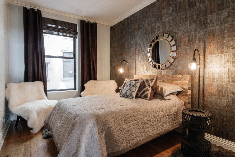 Immagine di una piccola camera degli ospiti industriale con pareti grigie e pavimento in legno massello medio