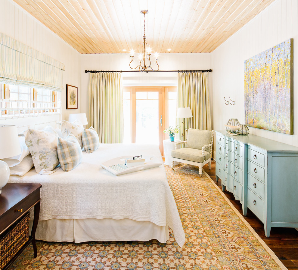 Foto de dormitorio costero con paredes blancas, suelo de madera oscura y suelo marrón