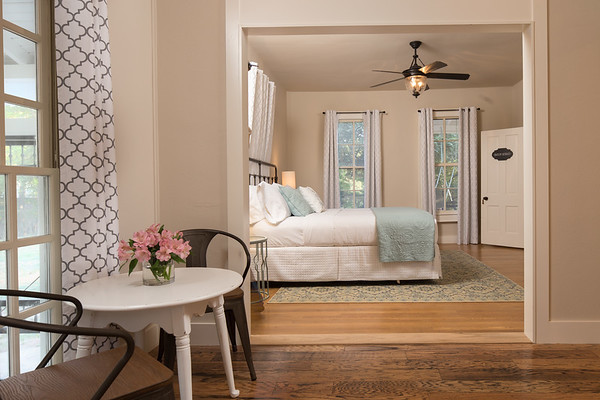 Foto di una piccola camera degli ospiti country con pareti beige, parquet chiaro, camino classico, cornice del camino in pietra e pavimento marrone