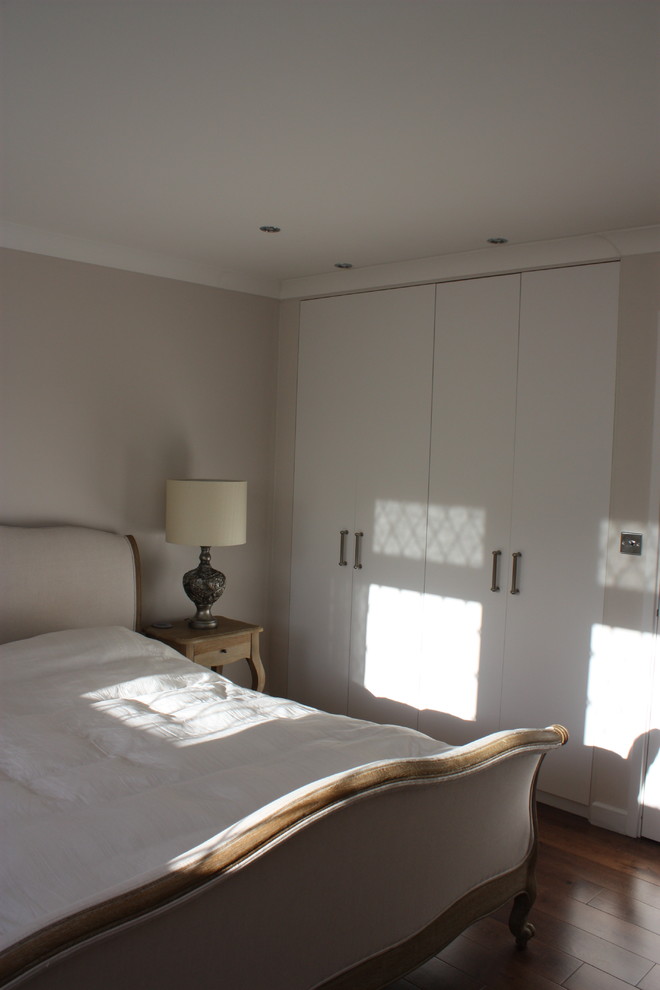 Идея дизайна: хозяйская спальня среднего размера в стиле неоклассика (современная классика) с бежевыми стенами и темным паркетным полом без камина