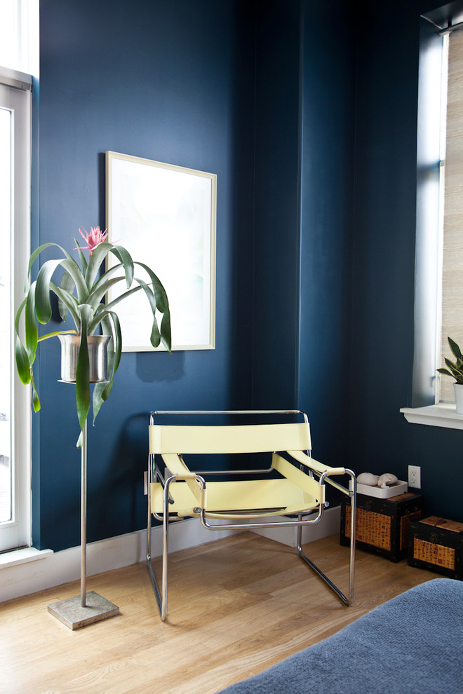 Mid-sized minimalist master light wood floor bedroom photo in New York with blue walls