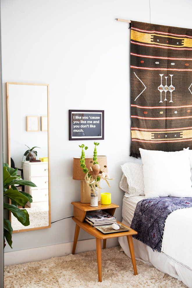 Cette image montre une chambre d'amis minimaliste de taille moyenne avec parquet clair et un mur gris.