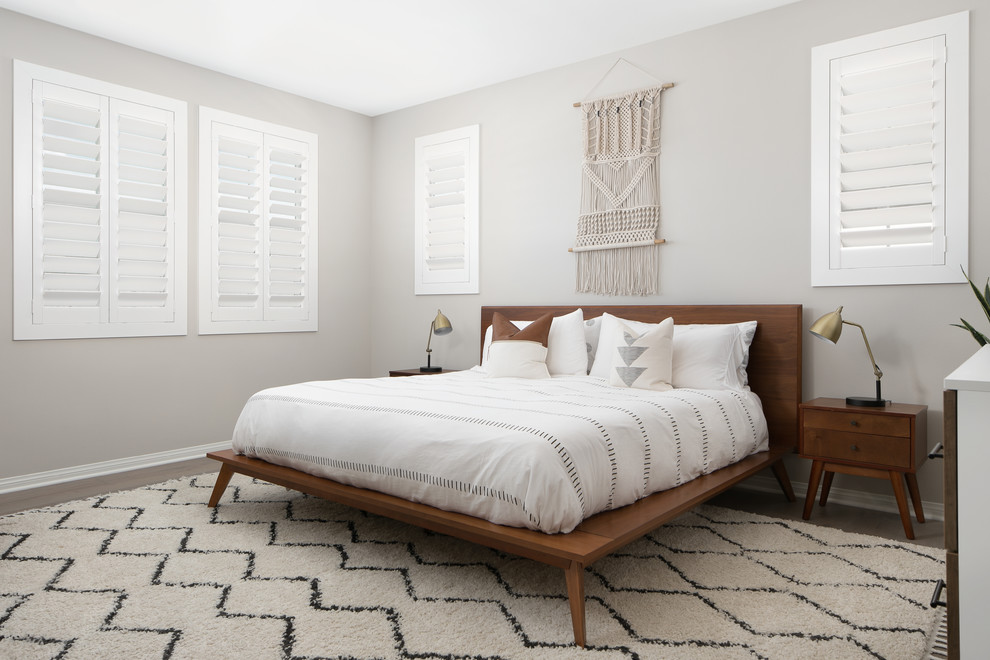 Idee per una camera da letto chic con pareti grigie, pavimento in legno massello medio e pavimento marrone