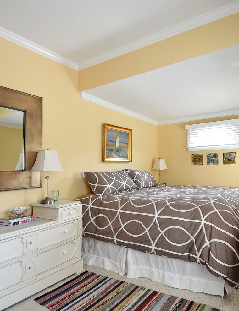 Exemple d'une chambre tendance avec un mur jaune.