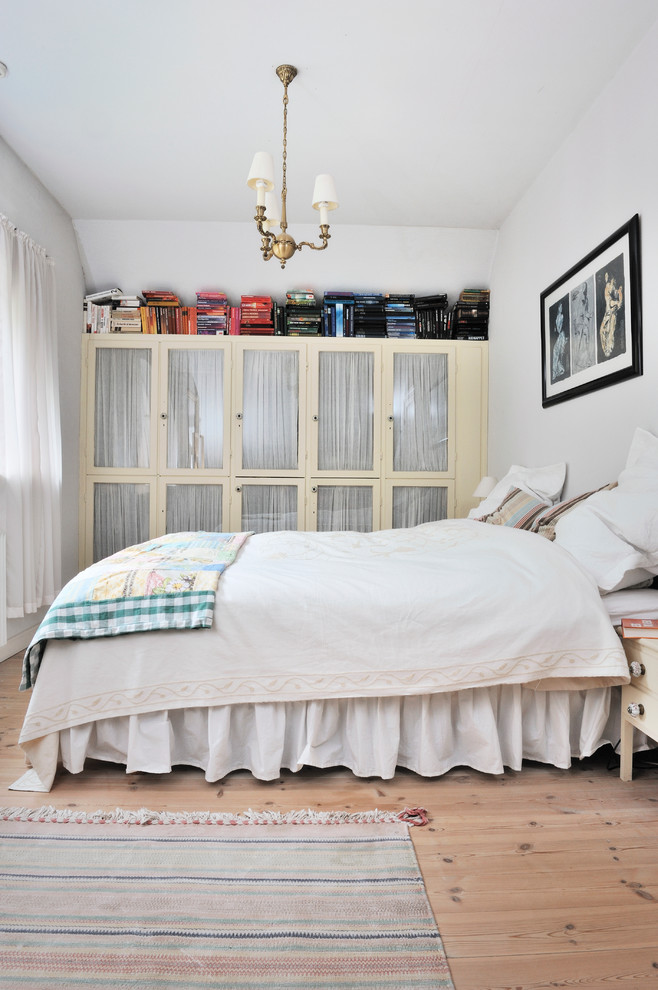 Medium sized scandinavian master bedroom in Aarhus with white walls, no fireplace and light hardwood flooring.