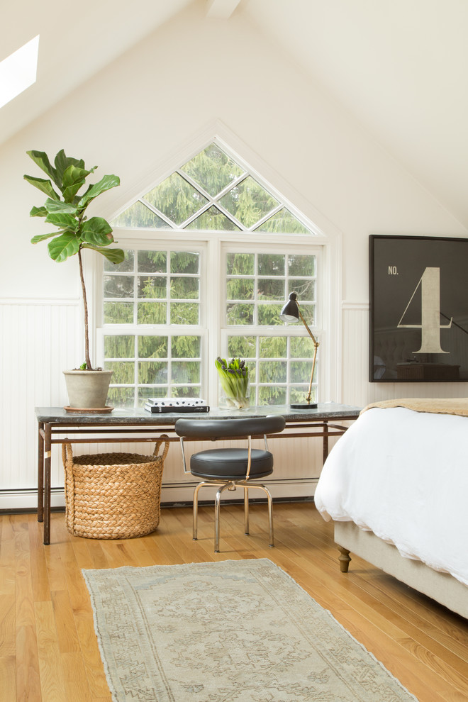 This is an example of a large classic master bedroom in Boston with white walls and medium hardwood flooring.