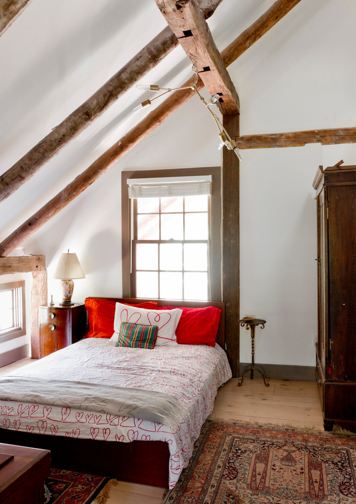 Diseño de habitación de invitados bohemia con paredes blancas y suelo de madera clara
