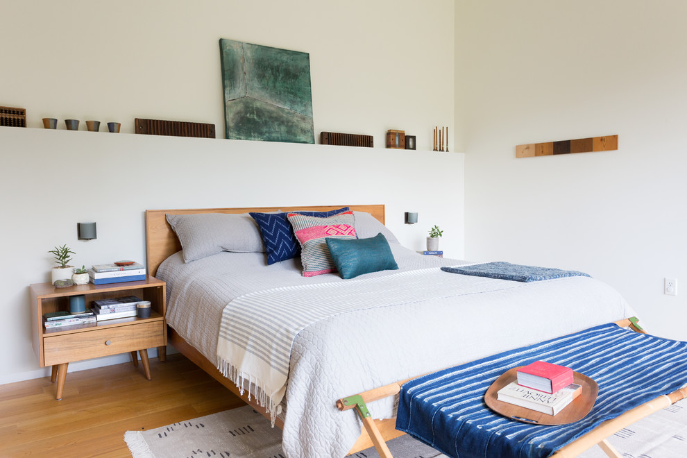 Großes Modernes Schlafzimmer mit weißer Wandfarbe, braunem Holzboden und braunem Boden in Kansas City
