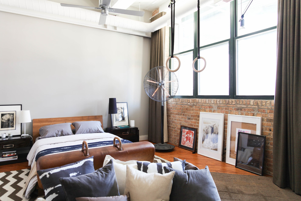 Industrial Schlafzimmer mit grauer Wandfarbe, braunem Holzboden und braunem Boden in Chicago