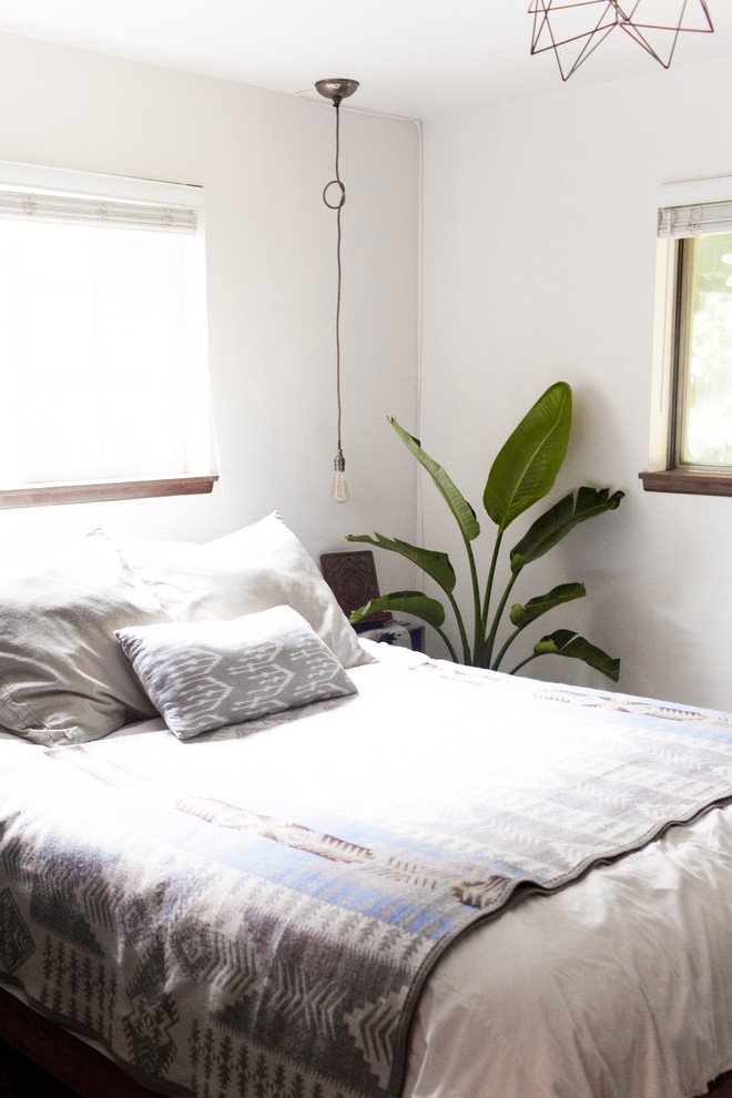 Foto de dormitorio principal de estilo americano pequeño con paredes blancas y suelo de madera en tonos medios