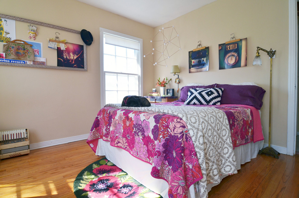 Stilmix Hauptschlafzimmer mit beiger Wandfarbe und braunem Holzboden in Dallas