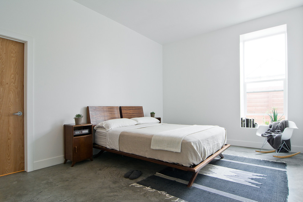 Cette photo montre une chambre rétro avec sol en béton ciré.