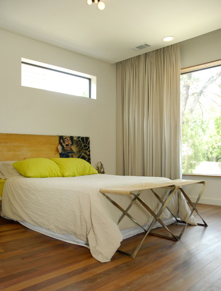 Immagine di una camera da letto minimalista con pareti beige e pavimento in legno massello medio