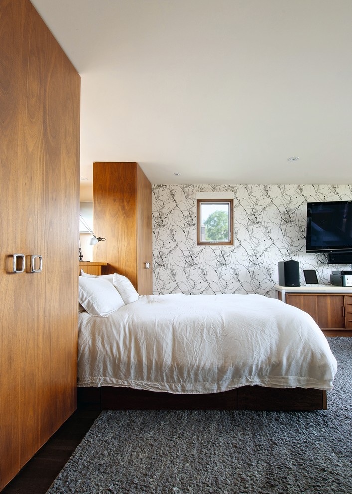 Ejemplo de dormitorio televisión tradicional renovado con paredes blancas y suelo de madera oscura