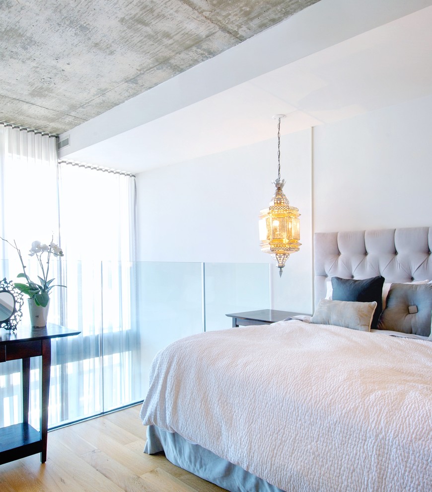 トロントにあるコンテンポラリースタイルのおしゃれなロフト寝室 (白い壁、淡色無垢フローリング、暖炉なし) のレイアウト