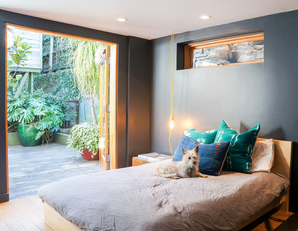 Foto på ett funkis sovrum, med grå väggar, mellanmörkt trägolv och brunt golv