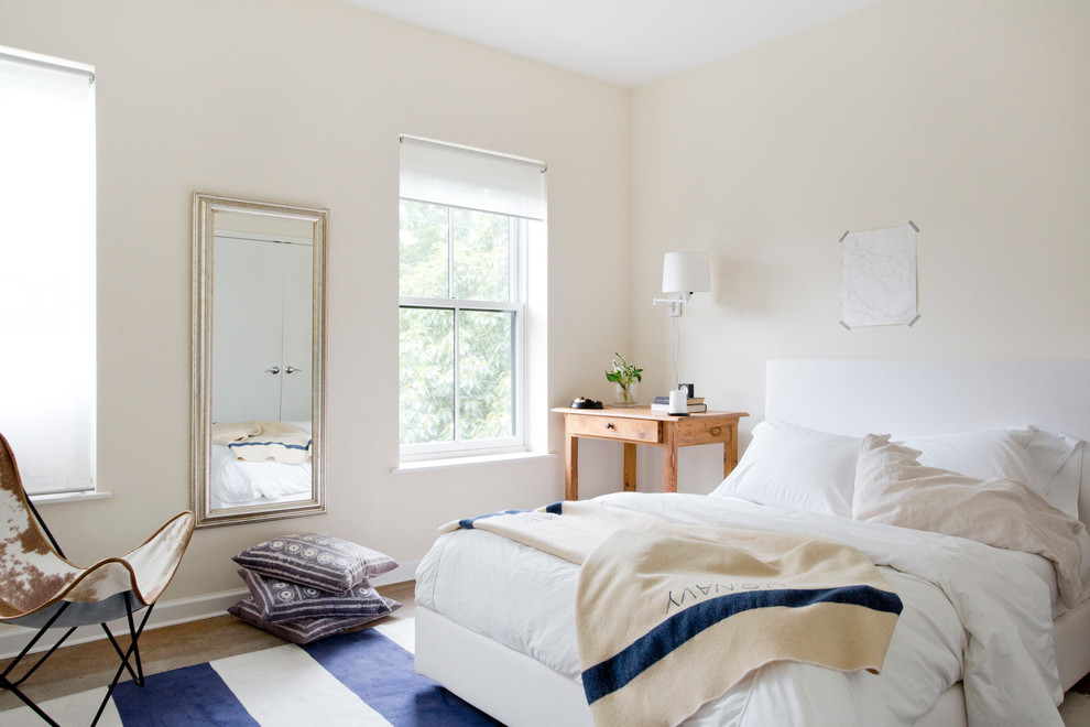 Cette image montre une chambre design avec un mur jaune, un sol en bois brun et aucune cheminée.