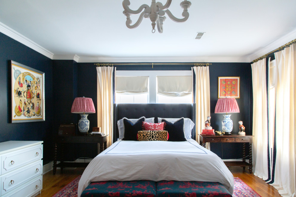 Modelo de habitación de invitados tradicional sin chimenea con paredes azules, suelo de madera en tonos medios y suelo marrón