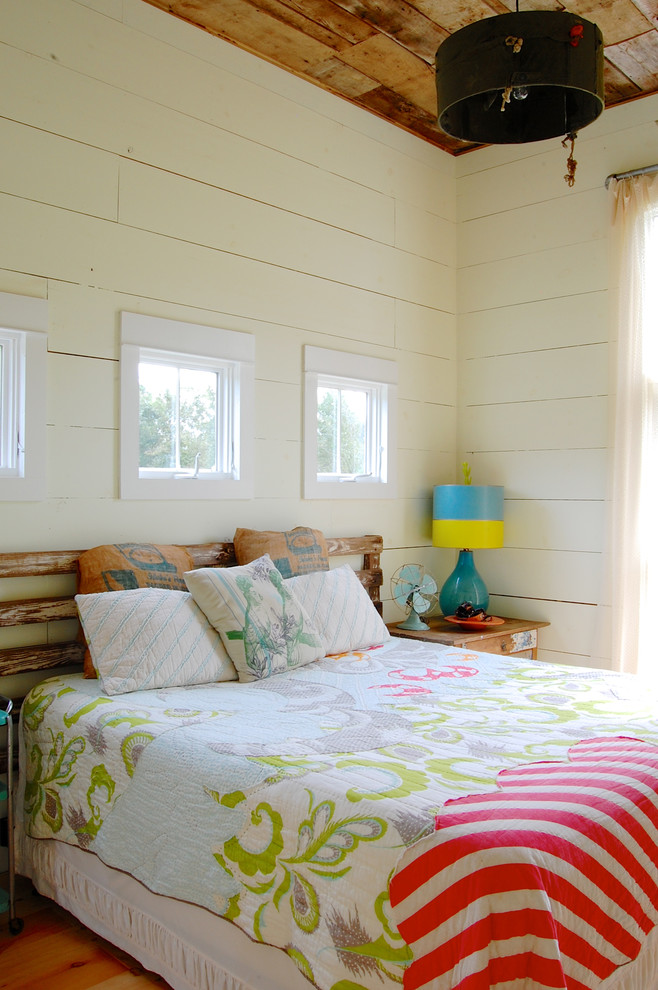 Landhaus Schlafzimmer ohne Kamin mit weißer Wandfarbe und braunem Holzboden in New York