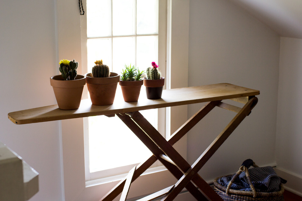 Modelo de habitación de invitados vintage pequeña con paredes blancas y suelo de madera en tonos medios