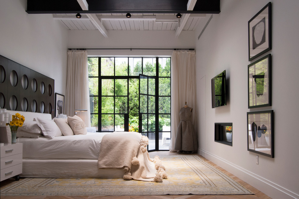 Imagen de dormitorio principal contemporáneo extra grande con paredes blancas, suelo de madera clara y chimenea lineal