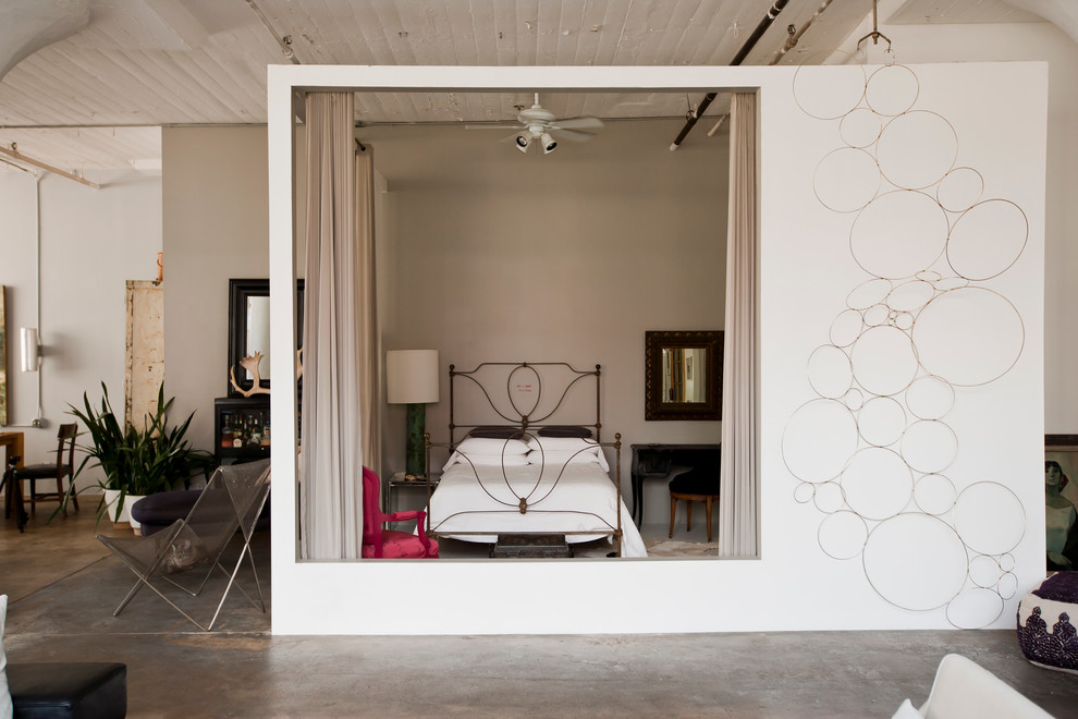 Diseño de dormitorio industrial sin chimenea con paredes grises y suelo de cemento