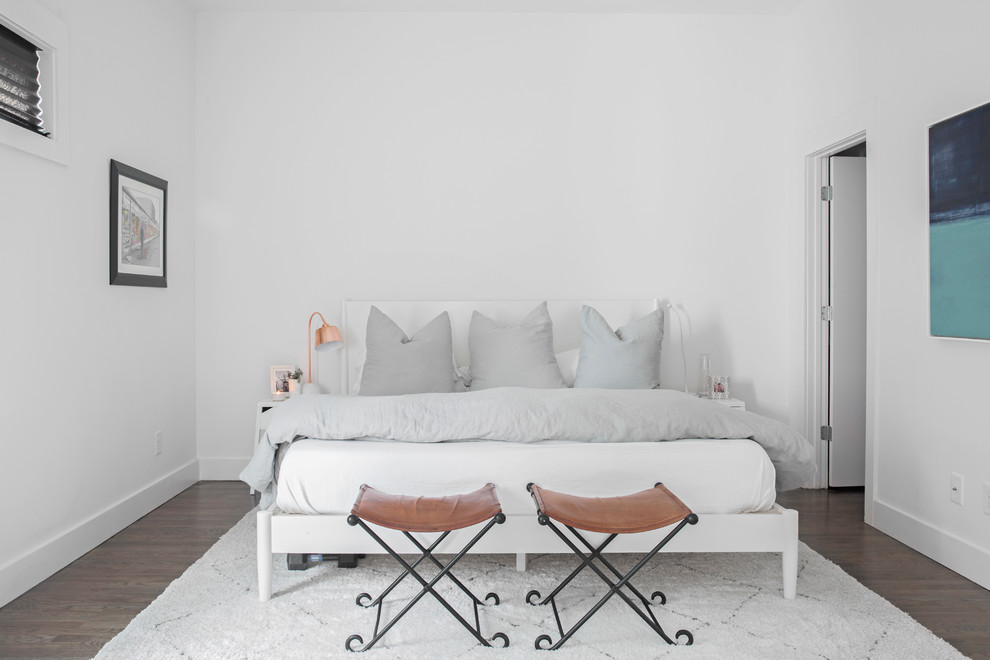 Imagen de dormitorio nórdico con paredes blancas, suelo de madera oscura y suelo marrón