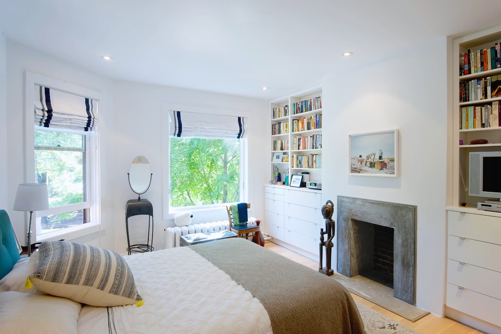 Example of a mid-sized danish master light wood floor bedroom design in Toronto with white walls, a standard fireplace and a concrete fireplace