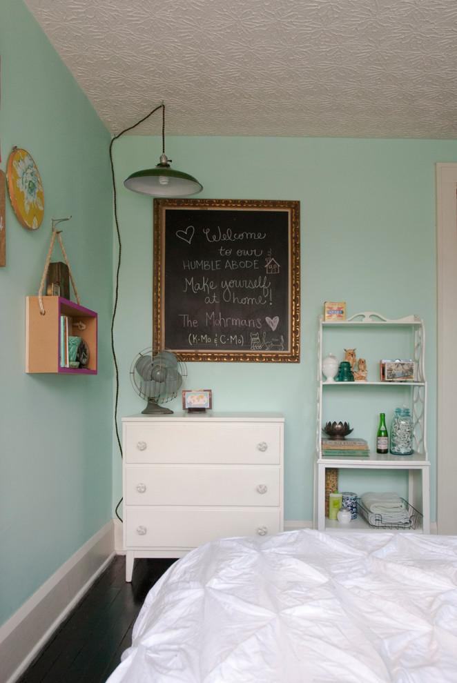Modelo de habitación de invitados bohemia pequeña sin chimenea con paredes azules y suelo de madera oscura