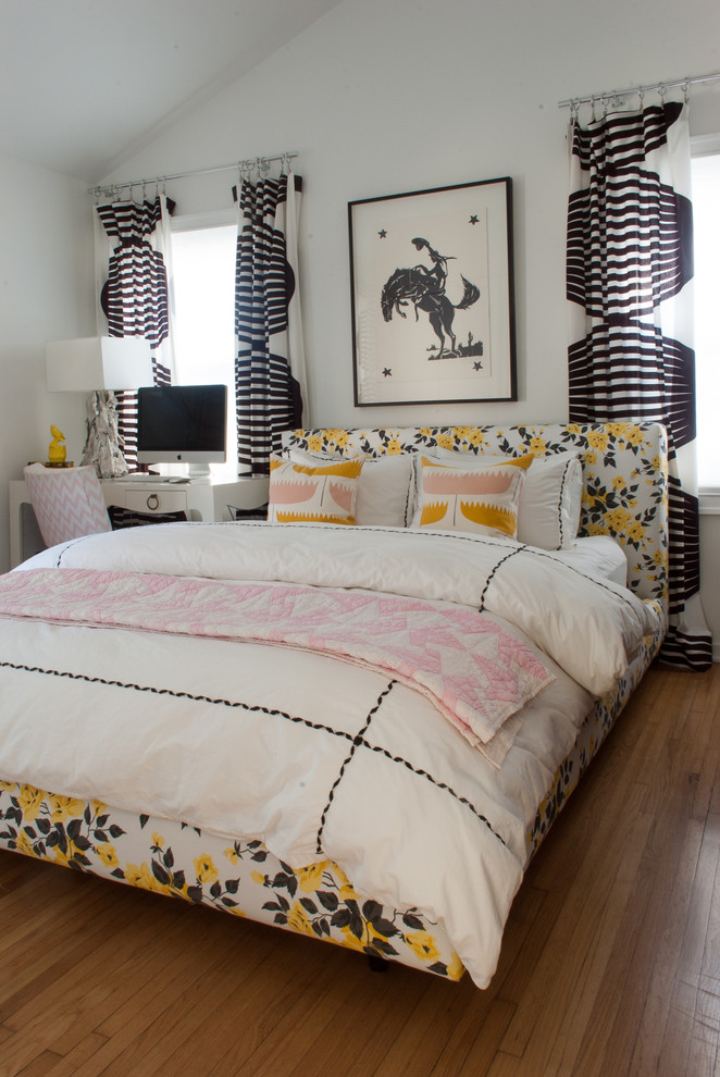 Foto di una camera da letto design con pareti bianche, pavimento in legno massello medio e nessun camino
